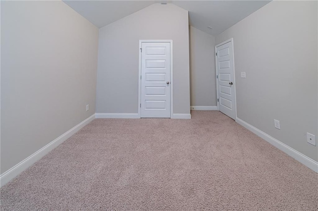 unfurnished bedroom featuring light colored carpet and lofted ceiling