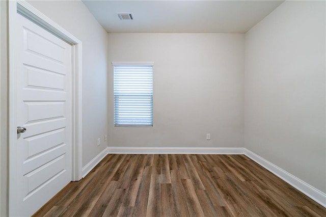 unfurnished room with dark wood-type flooring