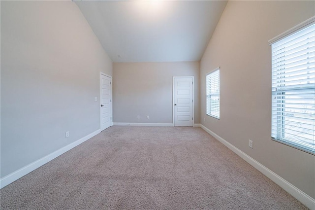 unfurnished room with light carpet and lofted ceiling