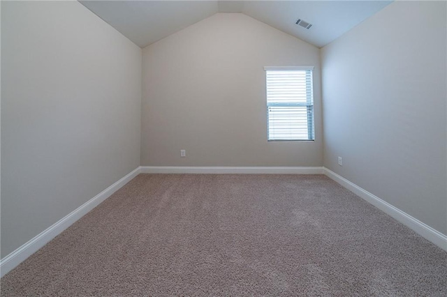 empty room featuring carpet flooring and lofted ceiling