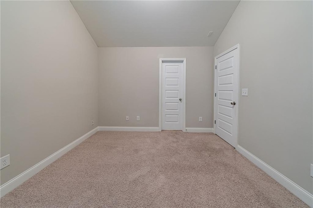 unfurnished bedroom featuring lofted ceiling and light carpet