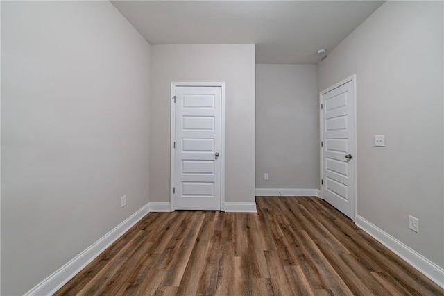 unfurnished room with dark wood-type flooring