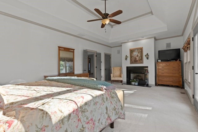 bedroom with a tray ceiling, ornamental molding, light colored carpet, and ceiling fan