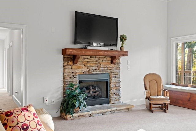 carpeted living room with a stone fireplace