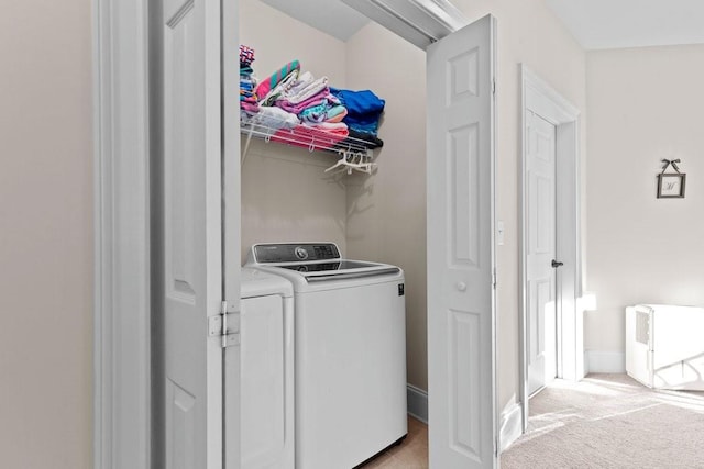 laundry room with independent washer and dryer and light colored carpet