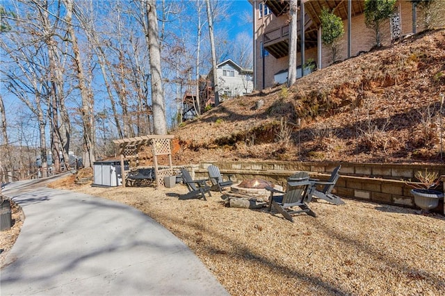 view of yard featuring a pergola and a fire pit