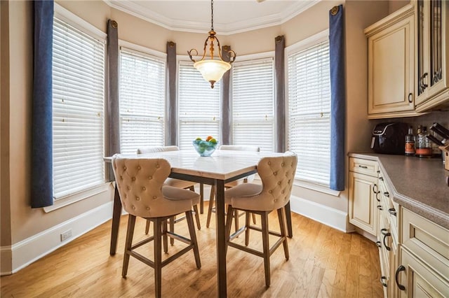 dining space with ornamental molding, plenty of natural light, and light wood-type flooring