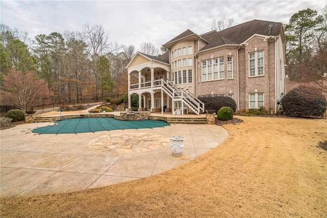 view of swimming pool featuring a diving board and a patio