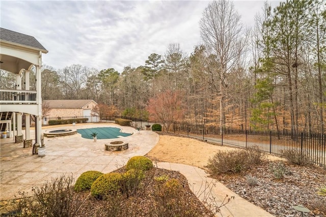 view of pool featuring a jacuzzi, a patio area, and a fire pit