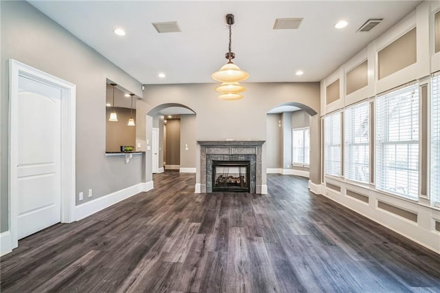 unfurnished living room featuring a premium fireplace and dark hardwood / wood-style flooring