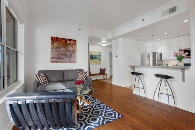 living room featuring hardwood / wood-style floors and crown molding