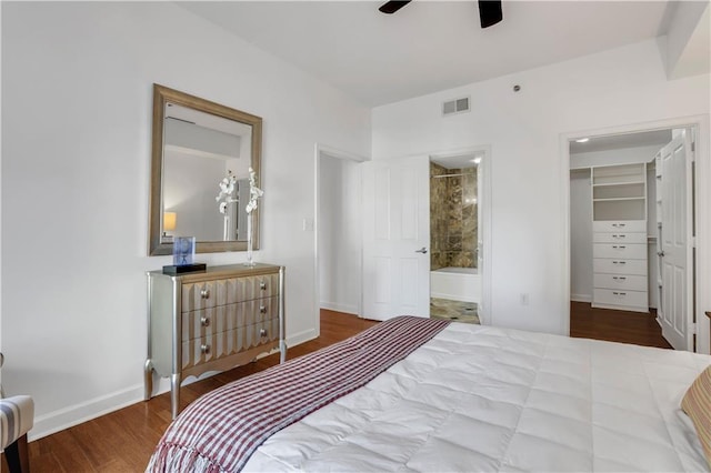 bedroom with connected bathroom, a closet, wood-type flooring, a spacious closet, and ceiling fan