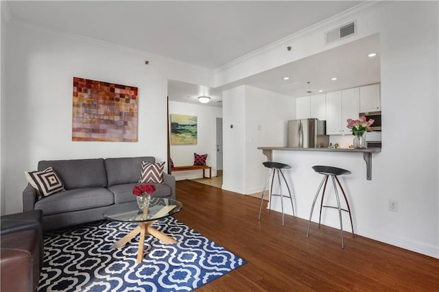 living room featuring ornamental molding and dark hardwood / wood-style flooring