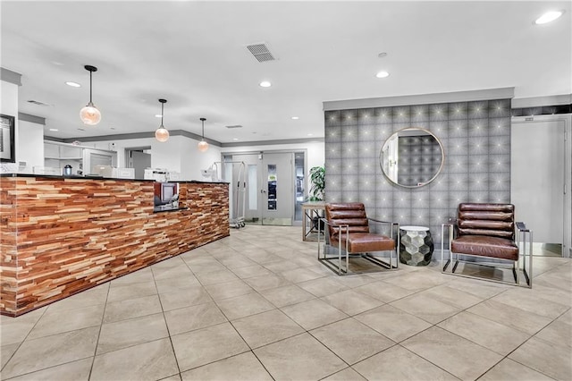 kitchen with light tile patterned flooring, ornamental molding, and decorative light fixtures