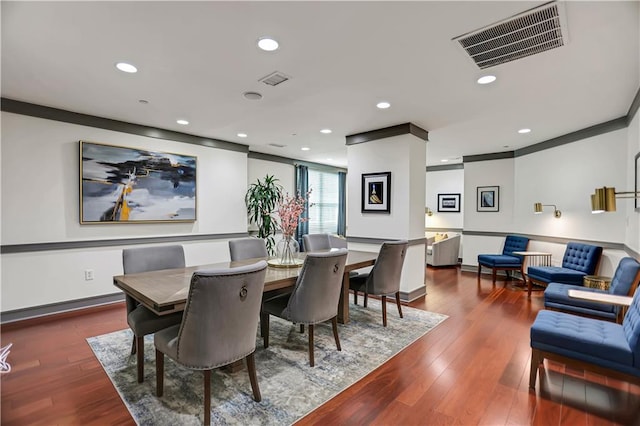 dining area with ornamental molding and hardwood / wood-style floors