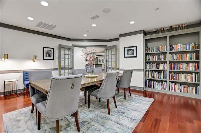 dining space featuring french doors, ornamental molding, and hardwood / wood-style floors