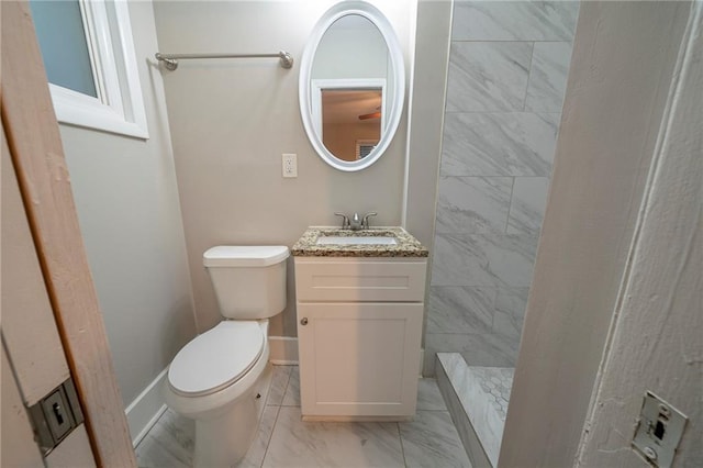 bathroom with vanity, a tile shower, and toilet