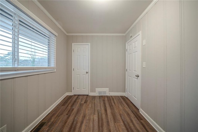 corridor with dark wood-type flooring and crown molding