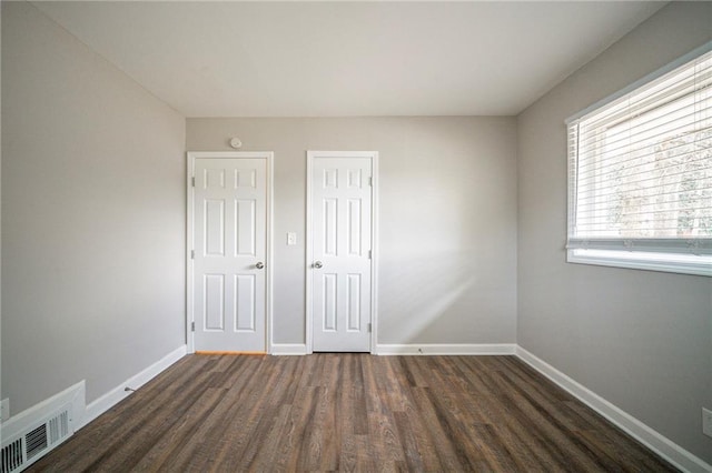 unfurnished bedroom with dark wood-type flooring