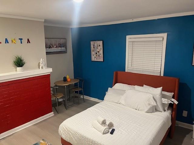 10 Rockmart Dr NW, Atlanta, GA 30314 - bedroom with baseboards, wood finished floors, and crown molding