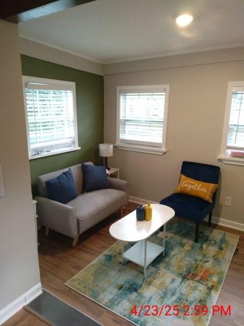 10 Rockmart Dr NW, Atlanta, GA 30314 - living area with healthy amount of natural light, ornamental molding, wood finished floors, and baseboards