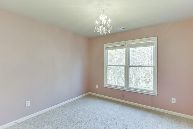 unfurnished room with carpet and an inviting chandelier