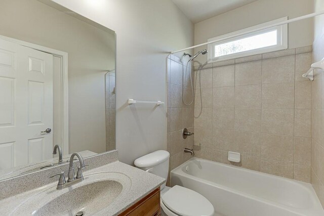 full bathroom with tiled shower / bath combo, toilet, and vanity