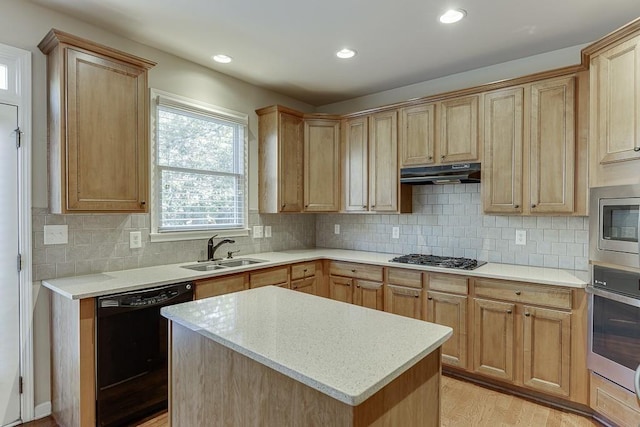 kitchen featuring appliances with stainless steel finishes, light wood-type flooring, backsplash, sink, and a kitchen island