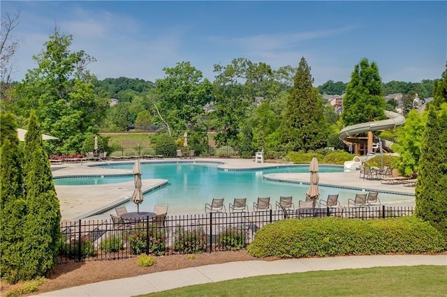 view of pool featuring a water slide and a patio