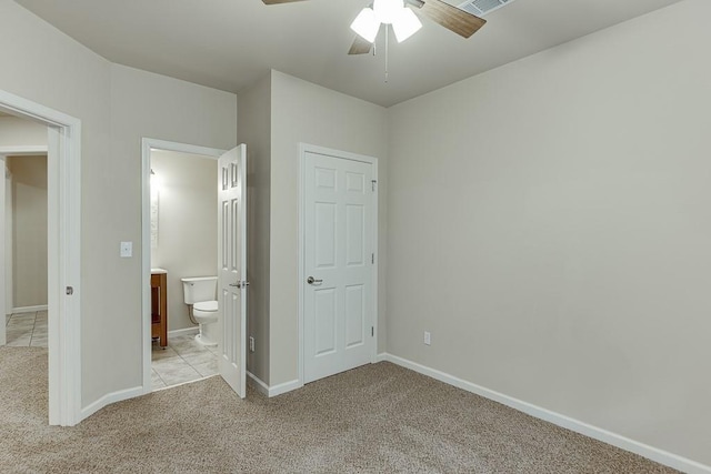 unfurnished bedroom with ceiling fan, light carpet, and ensuite bath