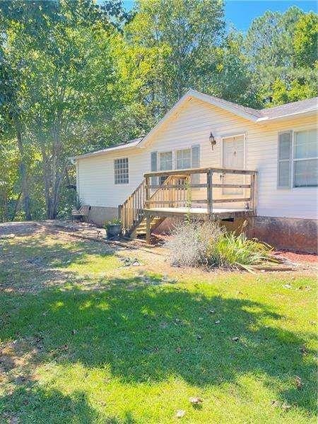 view of front of house with a deck and a front yard