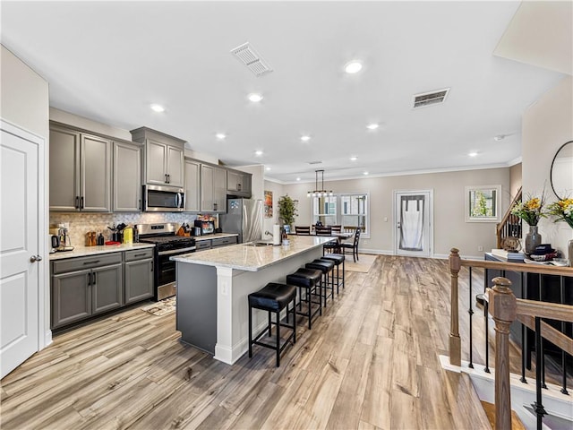 kitchen featuring visible vents, stainless steel appliances, gray cabinetry, and crown molding