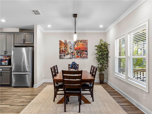 dining room with baseboards, wood finished floors, recessed lighting, and ornamental molding