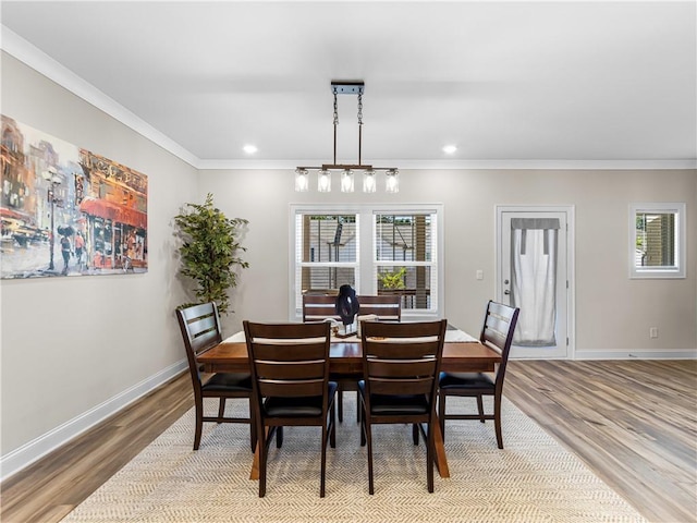 dining space with light wood finished floors, baseboards, and ornamental molding