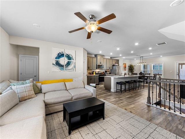 living room featuring recessed lighting, wood finished floors, visible vents, and ceiling fan