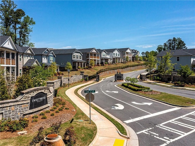 view of road with a residential view, sidewalks, and curbs