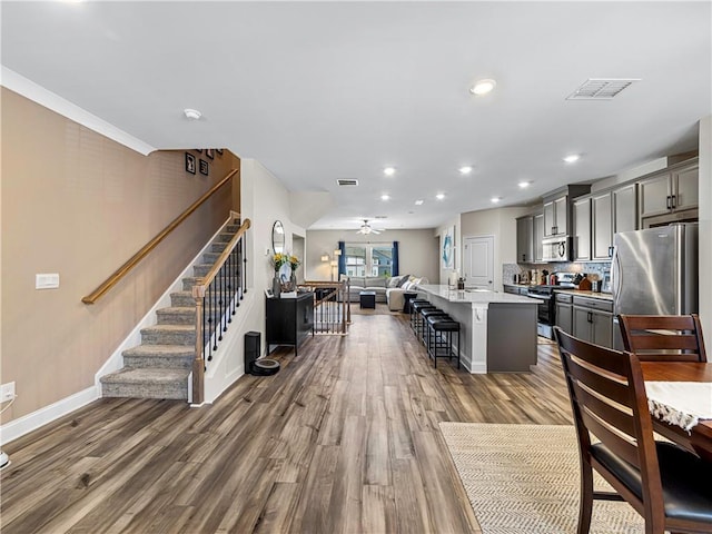 interior space with dark wood-type flooring, stairway, visible vents, and baseboards