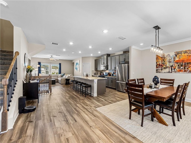dining room featuring stairway, ceiling fan, light wood-style flooring, visible vents, and recessed lighting