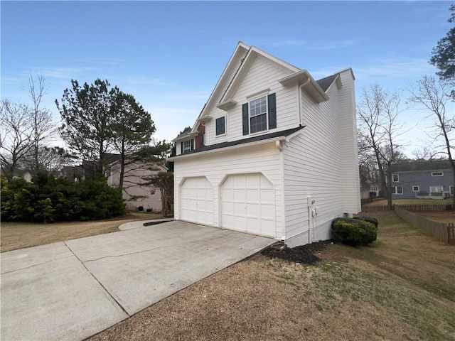 view of property exterior with an attached garage, fence, concrete driveway, and a yard