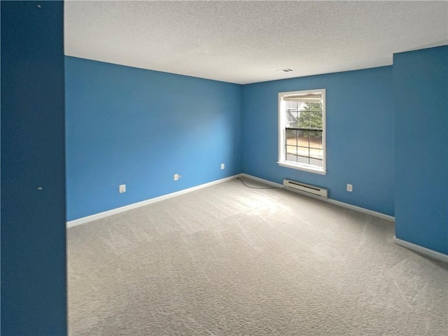 carpeted empty room with baseboards, baseboard heating, and a textured ceiling