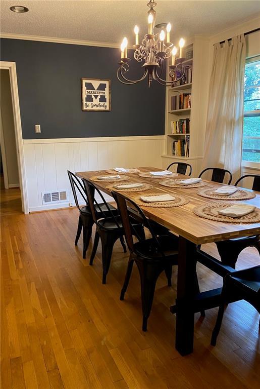 406 S Hillcrest Dr SW, Marietta, GA 30064 - dining area with a chandelier, ornamental molding, a wainscoted wall, and wood finished floors