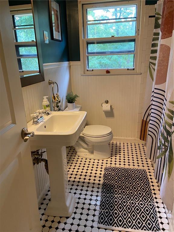 406 S Hillcrest Dr SW, Marietta, GA 30064 - bathroom with wainscoting, curtained shower, and tile patterned flooring