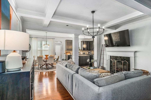 living room featuring coffered ceiling, ornamental molding, a high end fireplace, beam ceiling, and hardwood / wood-style floors