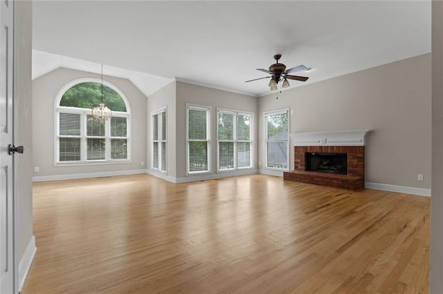 3642 Fowler Rdg, Douglasville, GA 30135 - unfurnished living room featuring light wood finished floors, a ceiling fan, baseboards, a brick fireplace, and a chandelier