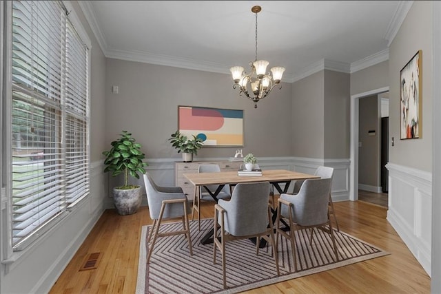 3642 Fowler Rdg, Douglasville, GA 30135 - dining room with ornamental molding, a chandelier, light wood-style floors, and wainscoting