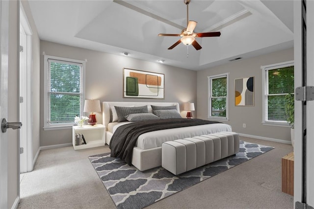 3642 Fowler Rdg, Douglasville, GA 30135 - carpeted bedroom featuring a tray ceiling, baseboards, multiple windows, and a ceiling fan