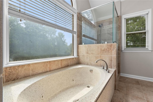 3642 Fowler Rdg, Douglasville, GA 30135 - bathroom featuring healthy amount of natural light, a stall shower, a tub with jets, and baseboards
