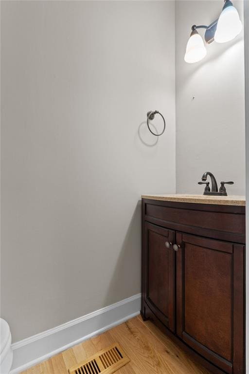 3642 Fowler Rdg, Douglasville, GA 30135 - bathroom featuring vanity, wood finished floors, baseboards, and toilet