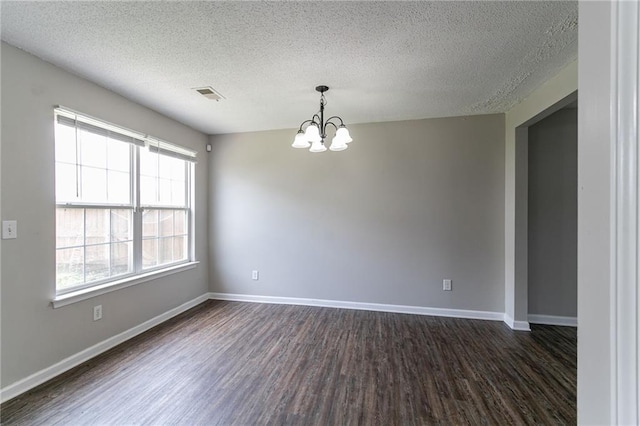 256 Turnstone Rd, Stockbridge, GA 30281 - spare room with a chandelier, dark wood-style flooring, a textured ceiling, and baseboards