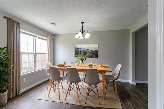 256 Turnstone Rd, Stockbridge, GA 30281 - dining area with a chandelier, dark wood-style flooring, baseboards, and a textured ceiling
